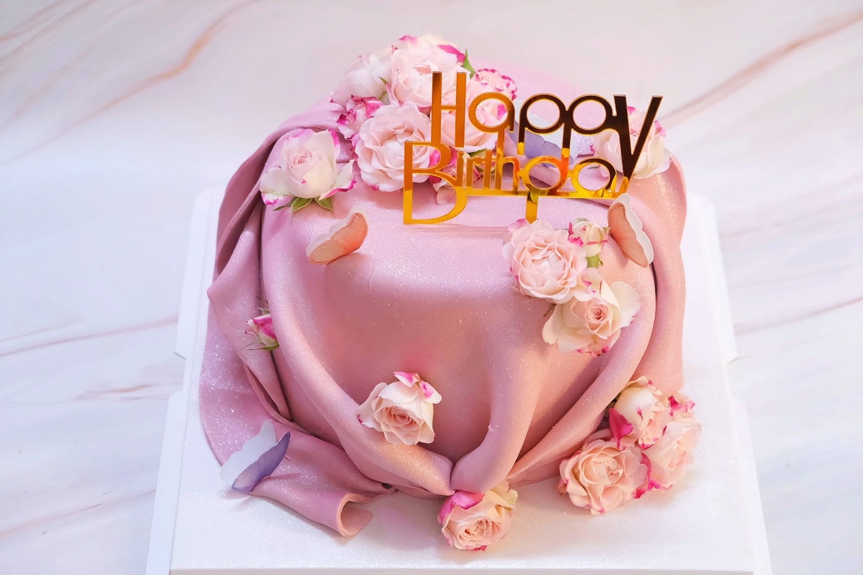 Draped pink fondant birthday cake with roses