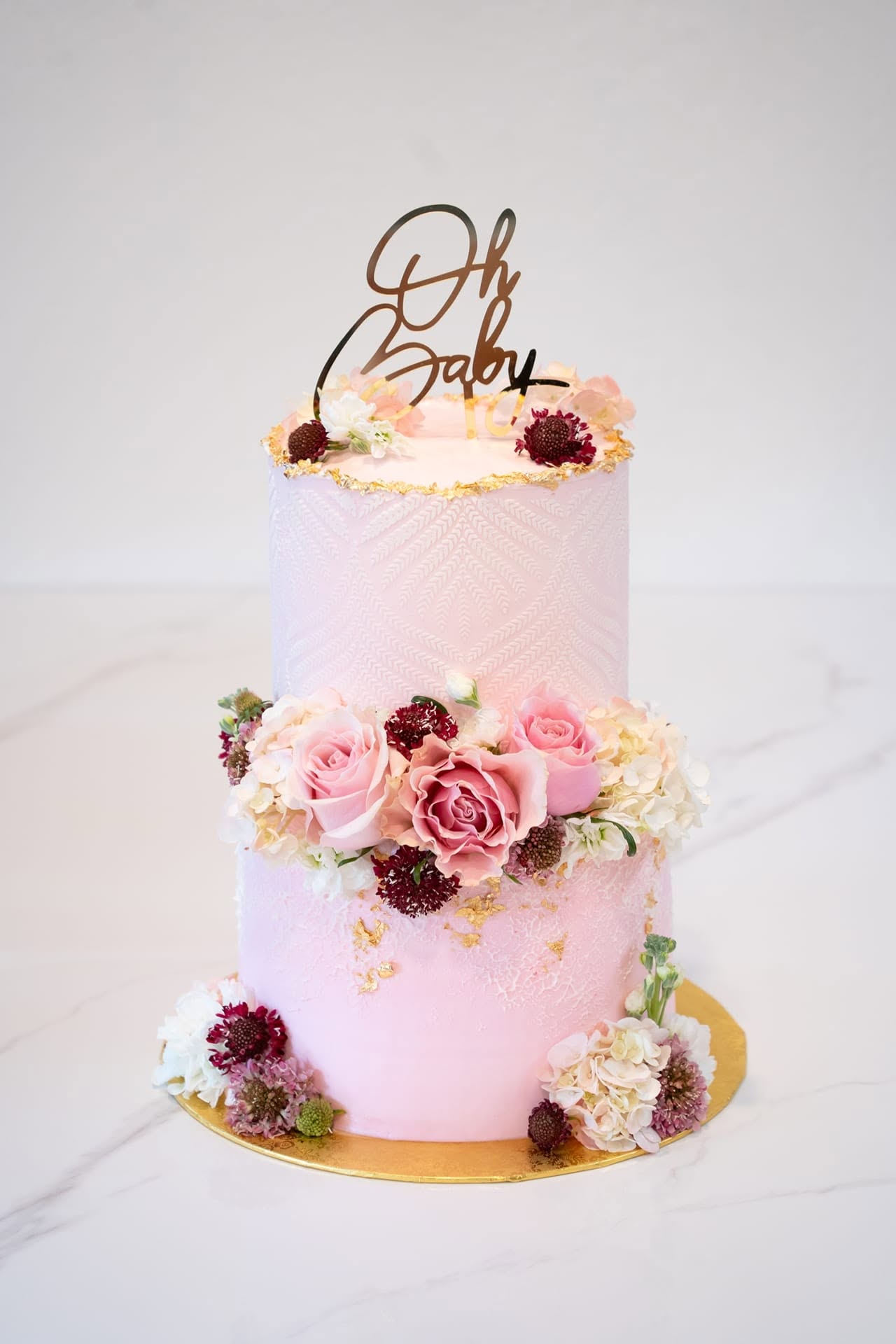 Two-tier Oh Baby cake with burgundy florals