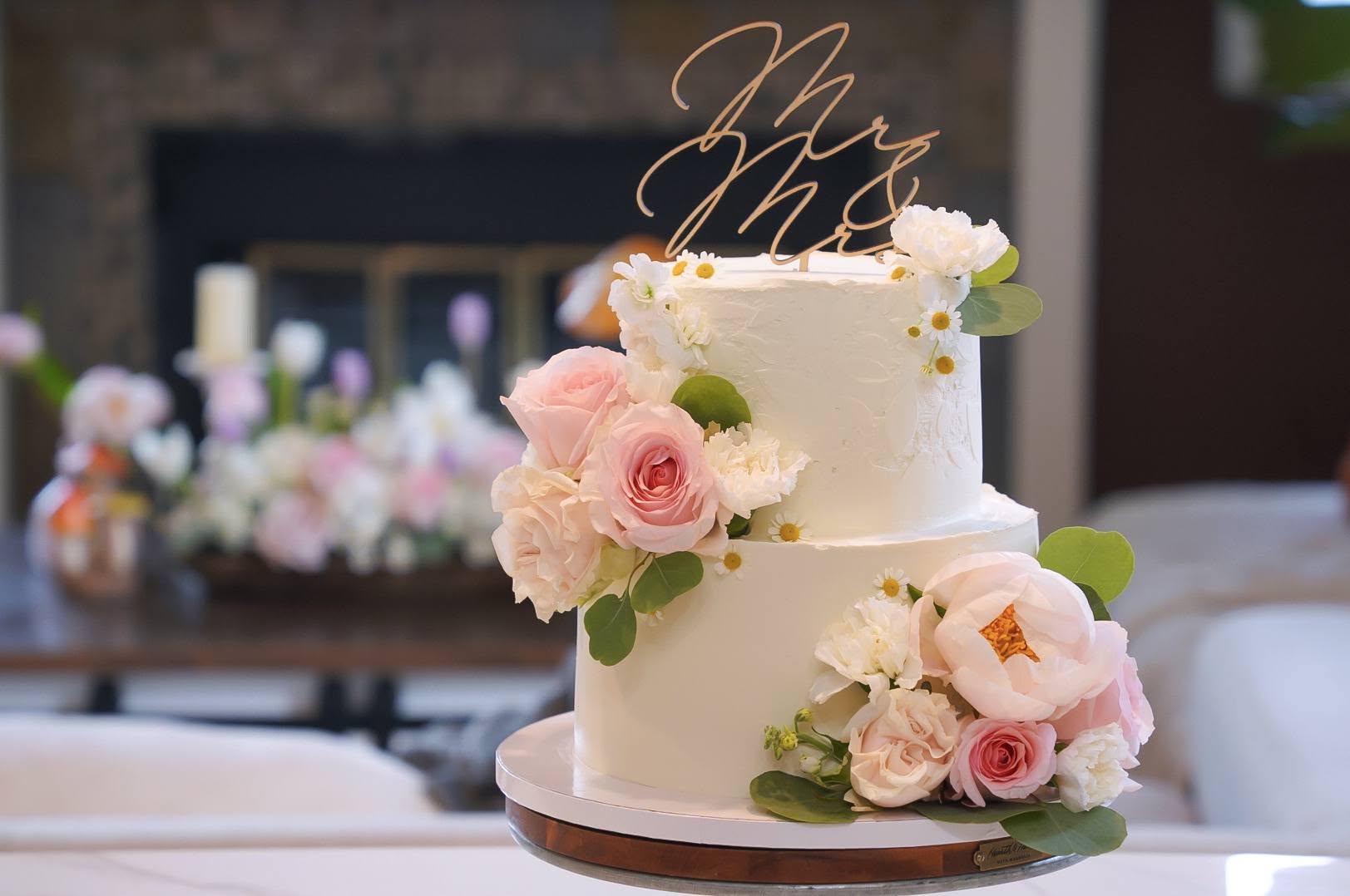Two-tier buttercream wedding cake with garden roses and peonies