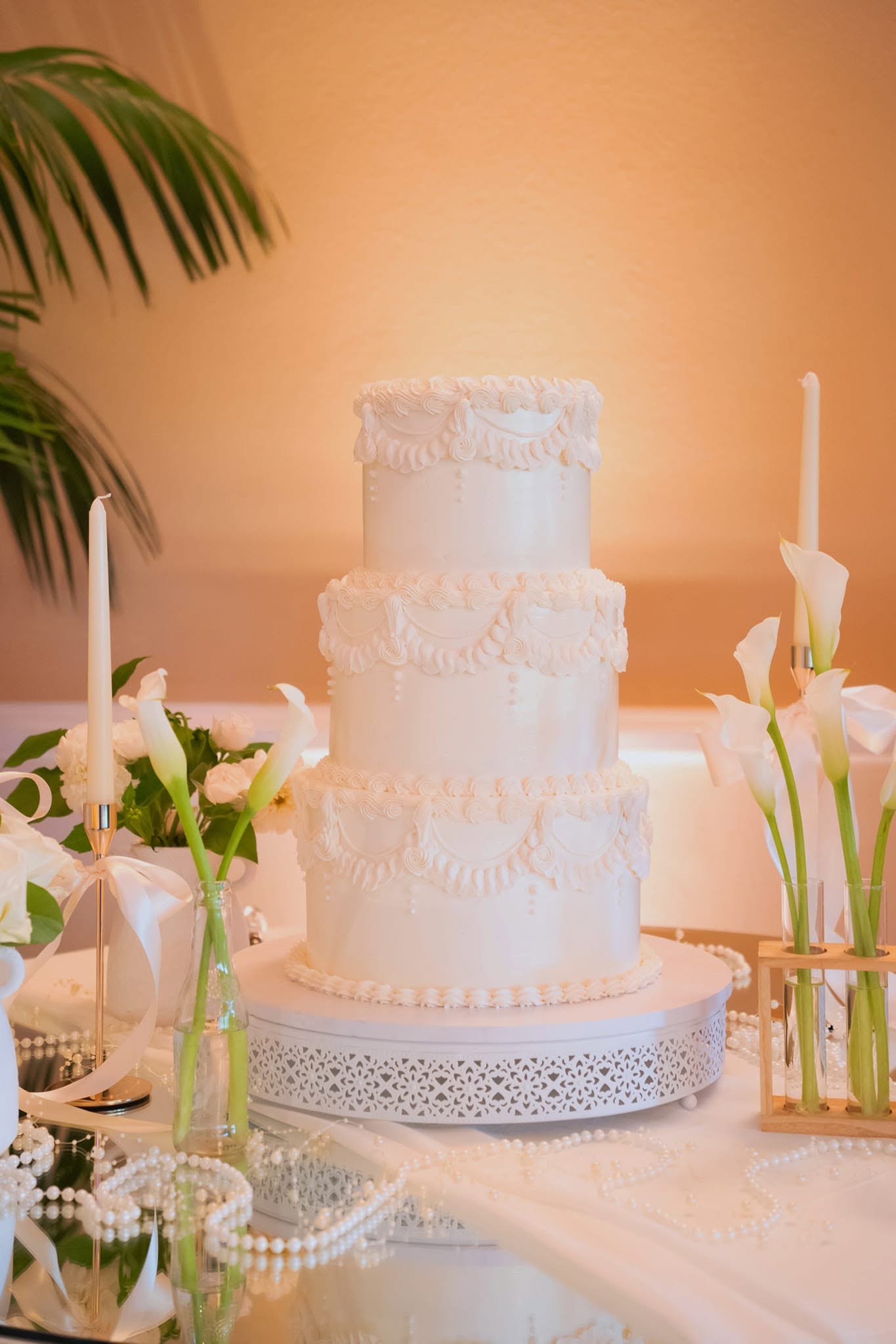 Three-tier white vintage piped wedding cake with pearls